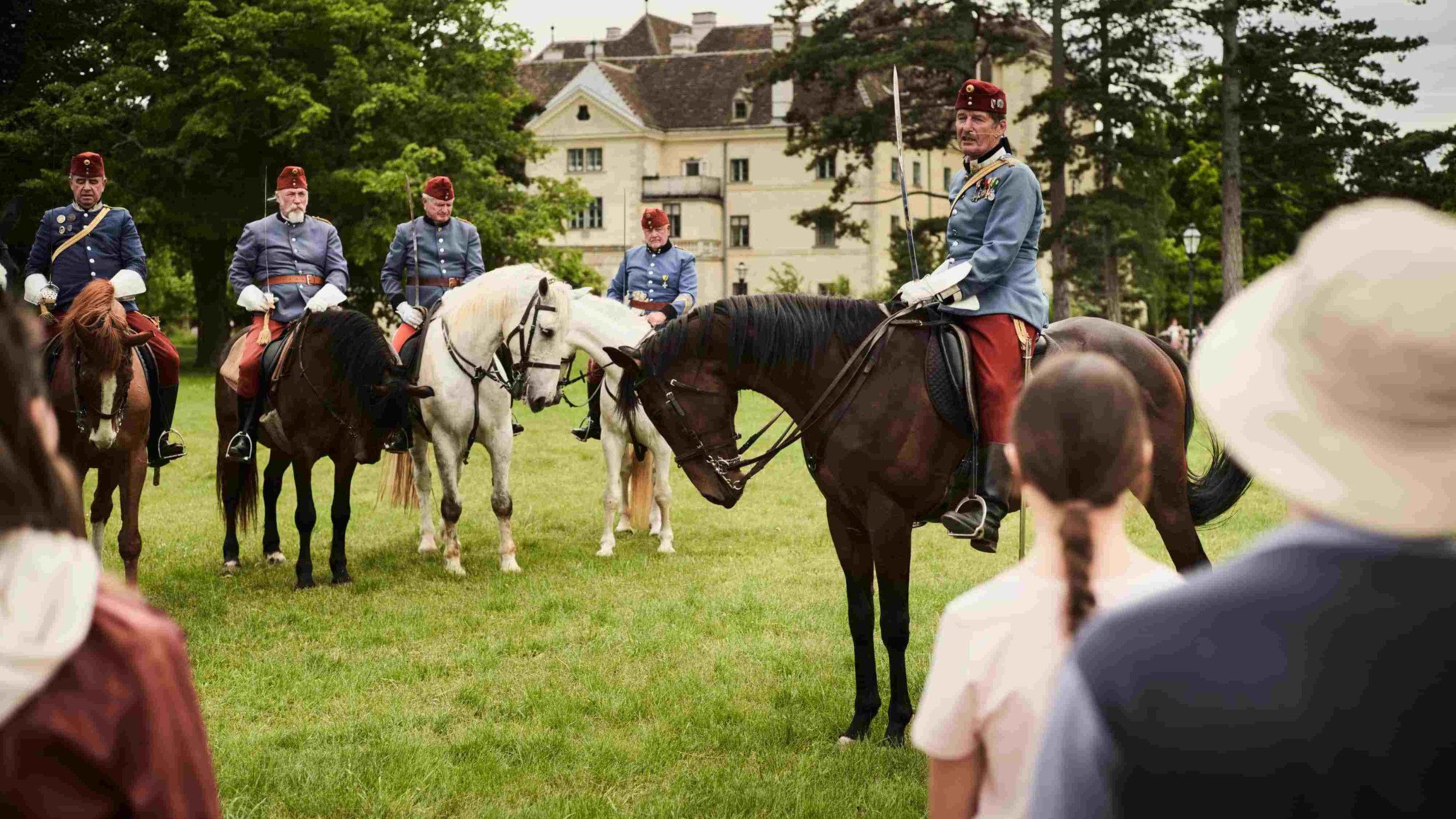 Kaiserlich gekleidete Reiter mit ihren Pferden im Schlosspark Laxenburg.