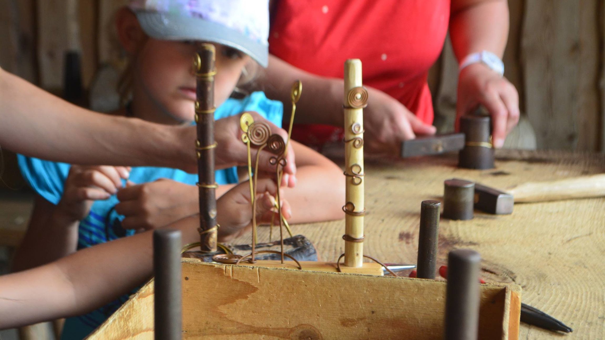 Kinder lernen im Keltendorf, wie Schmuck aus Metall hergestellt wurde und wie sich die Leute schmückten.