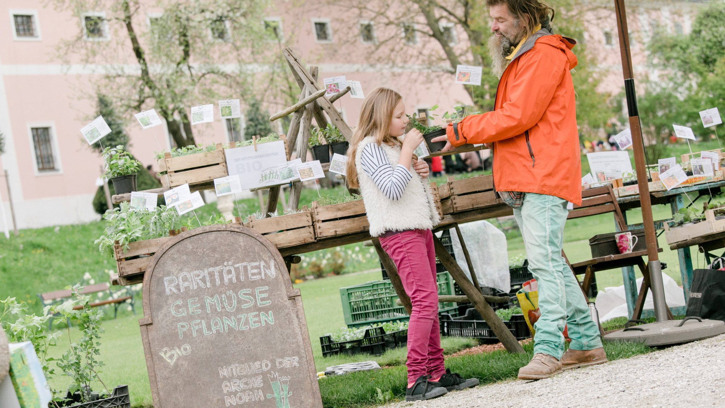 Blick auf Vater und Tochter, die beim Pflanzenmarkt stehen.