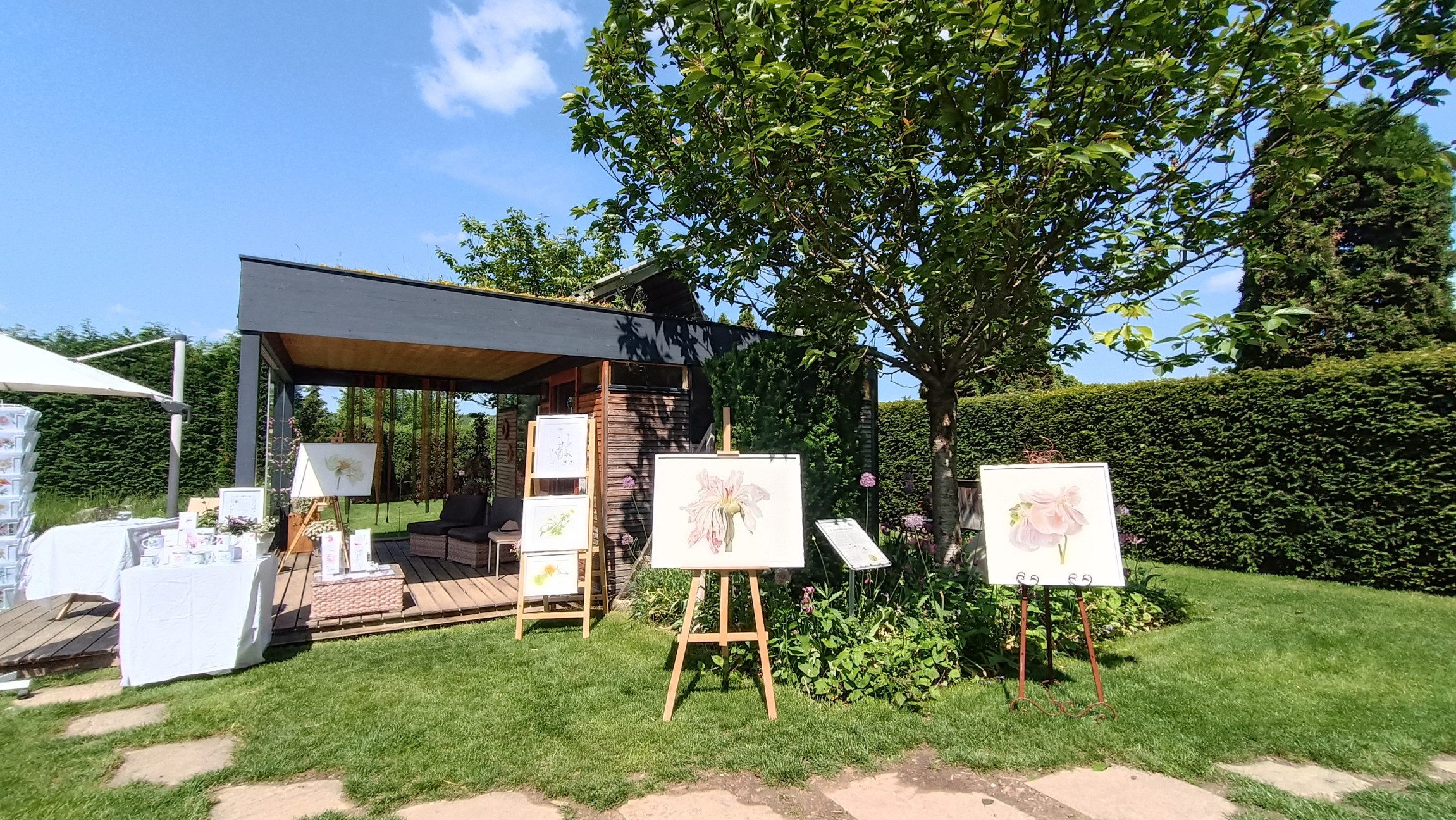 Künstlerische Werke und Bilder inmitten der grünen Wiese.